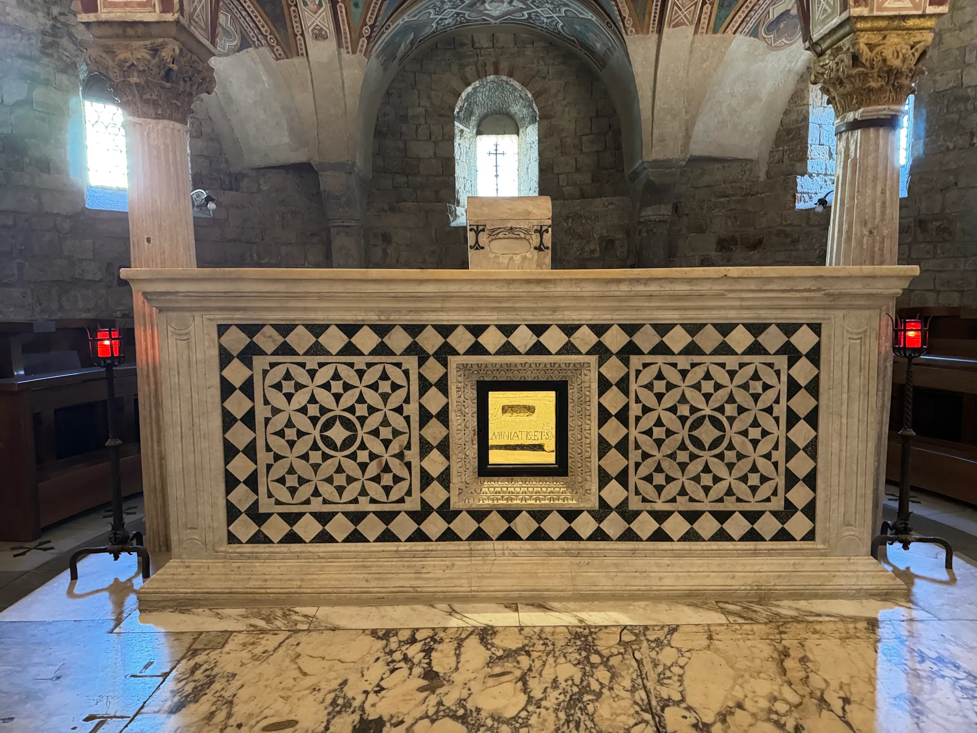 The altar over the tomb of Saint Minias in the crypt of San Miniato, its front inlaid in white and green marble.