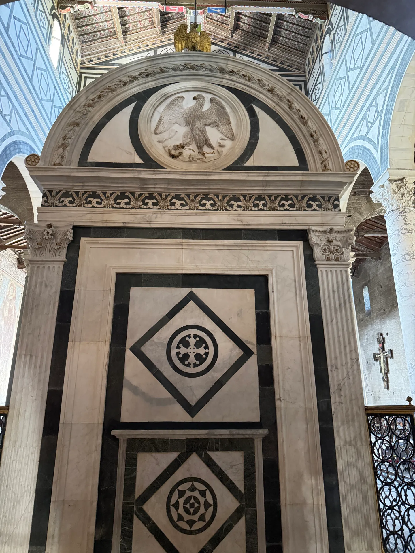 An eagle carved in a marble roundel on the Chapel of the Crucifix, the badge of the Arte di Calimala.