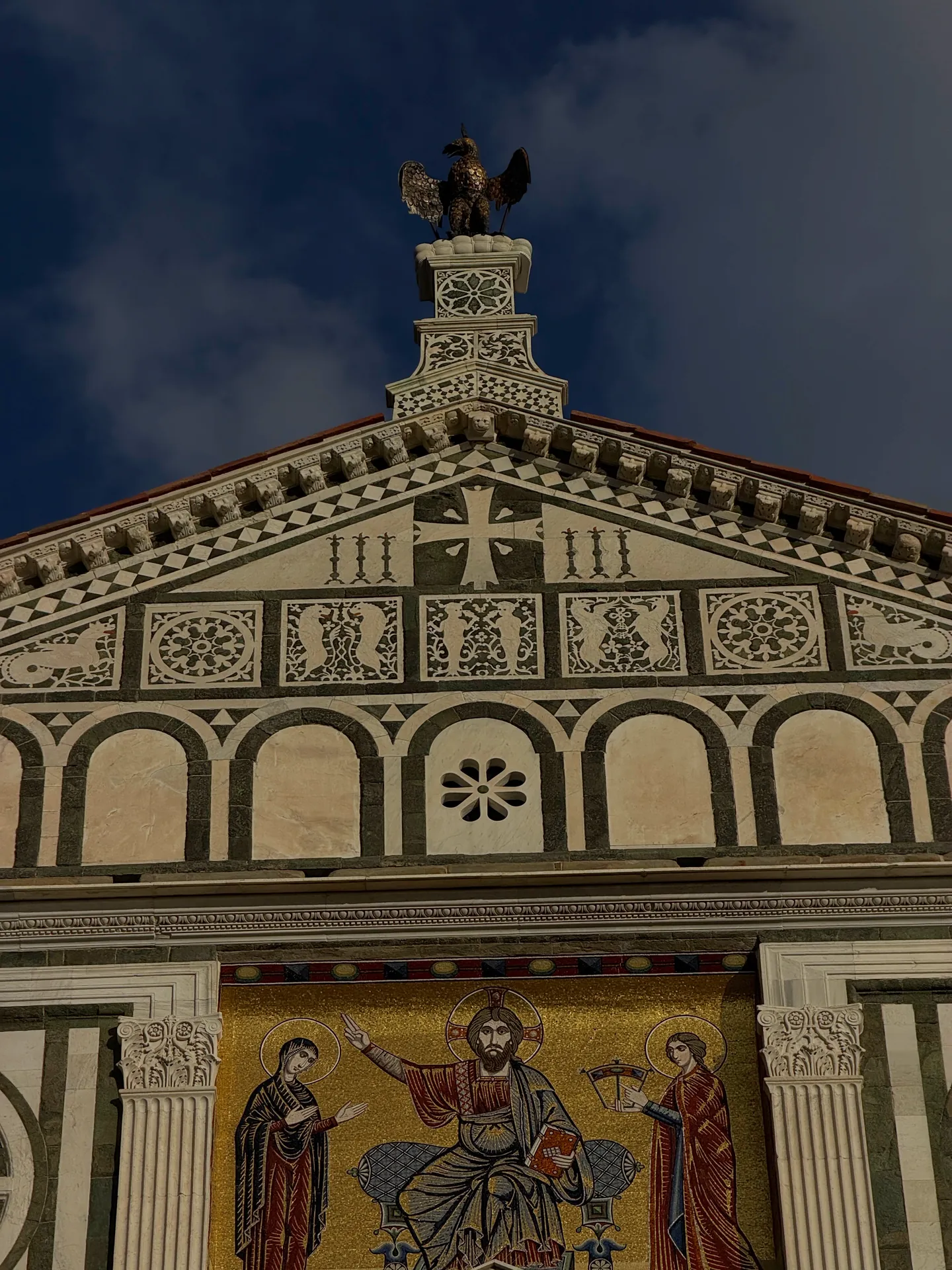 The upper gable of San Miniato with the Arte di Calimala eagle above the facade mosaic.