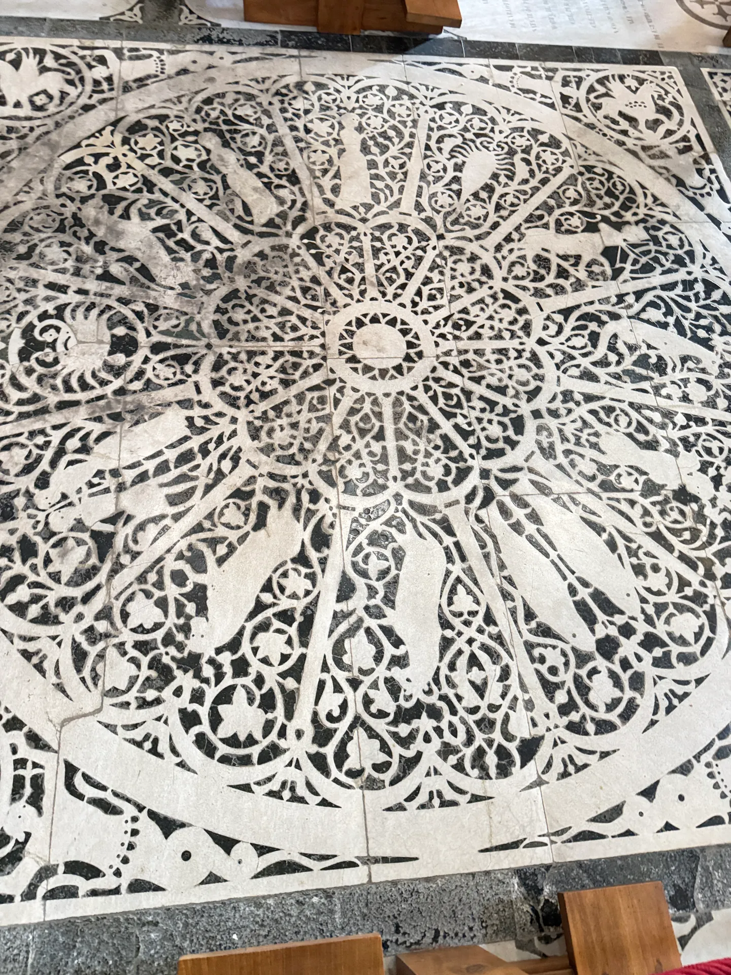 A great circular inlaid panel in the pavement of San Miniato, its radiating openwork worked in white and green marble.