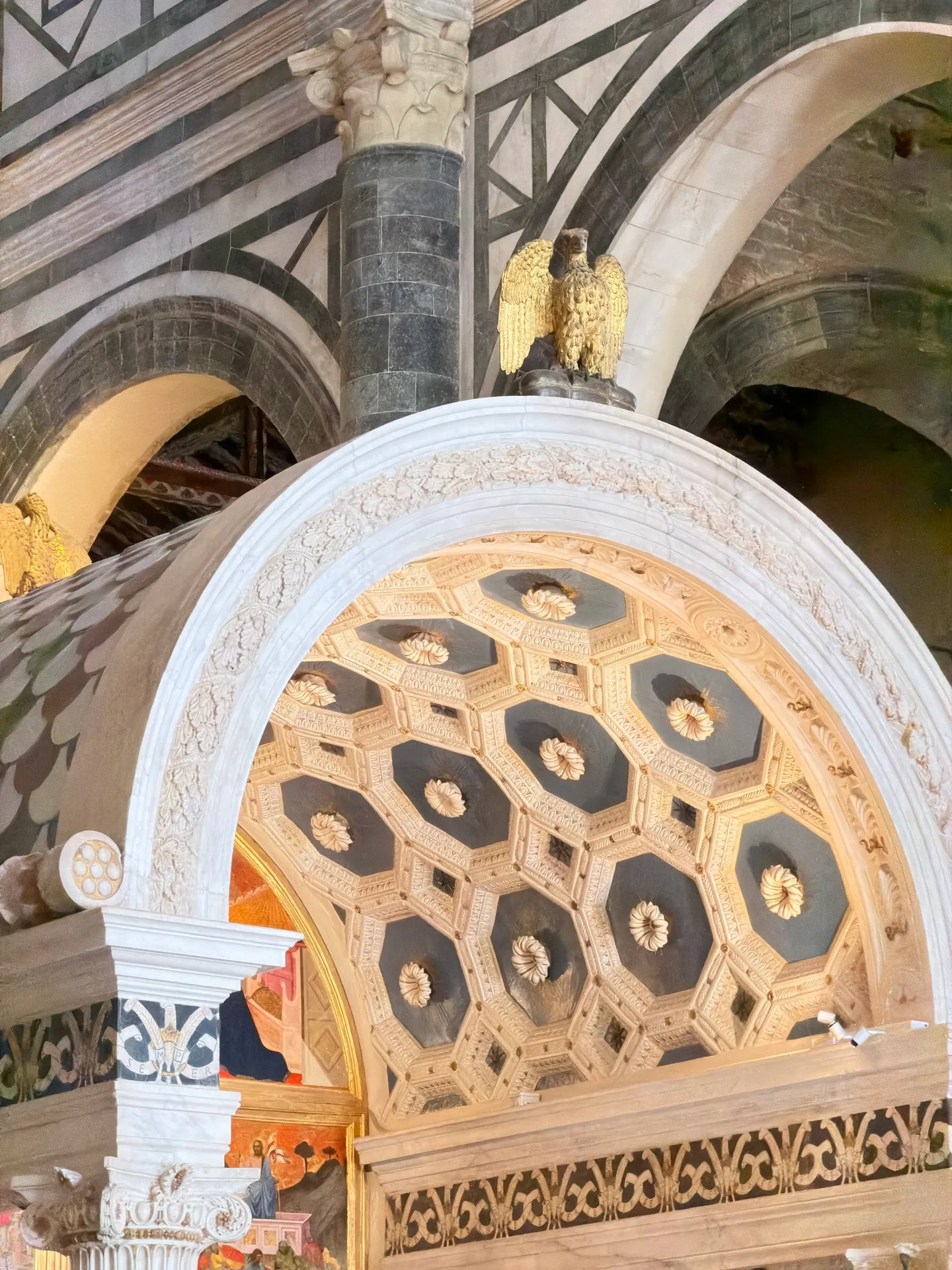 The coffered barrel canopy of the Chapel of the Crucifix in glazed terracotta, with a gilded eagle above.
