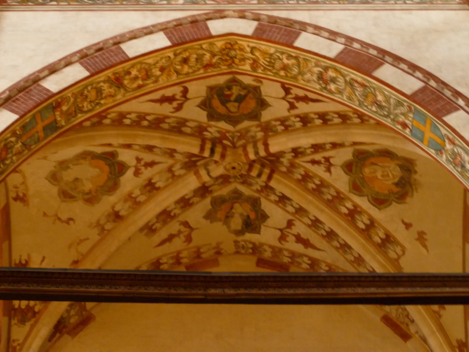 A frescoed arch with painted roundels inside Santa Anastasia in Verona