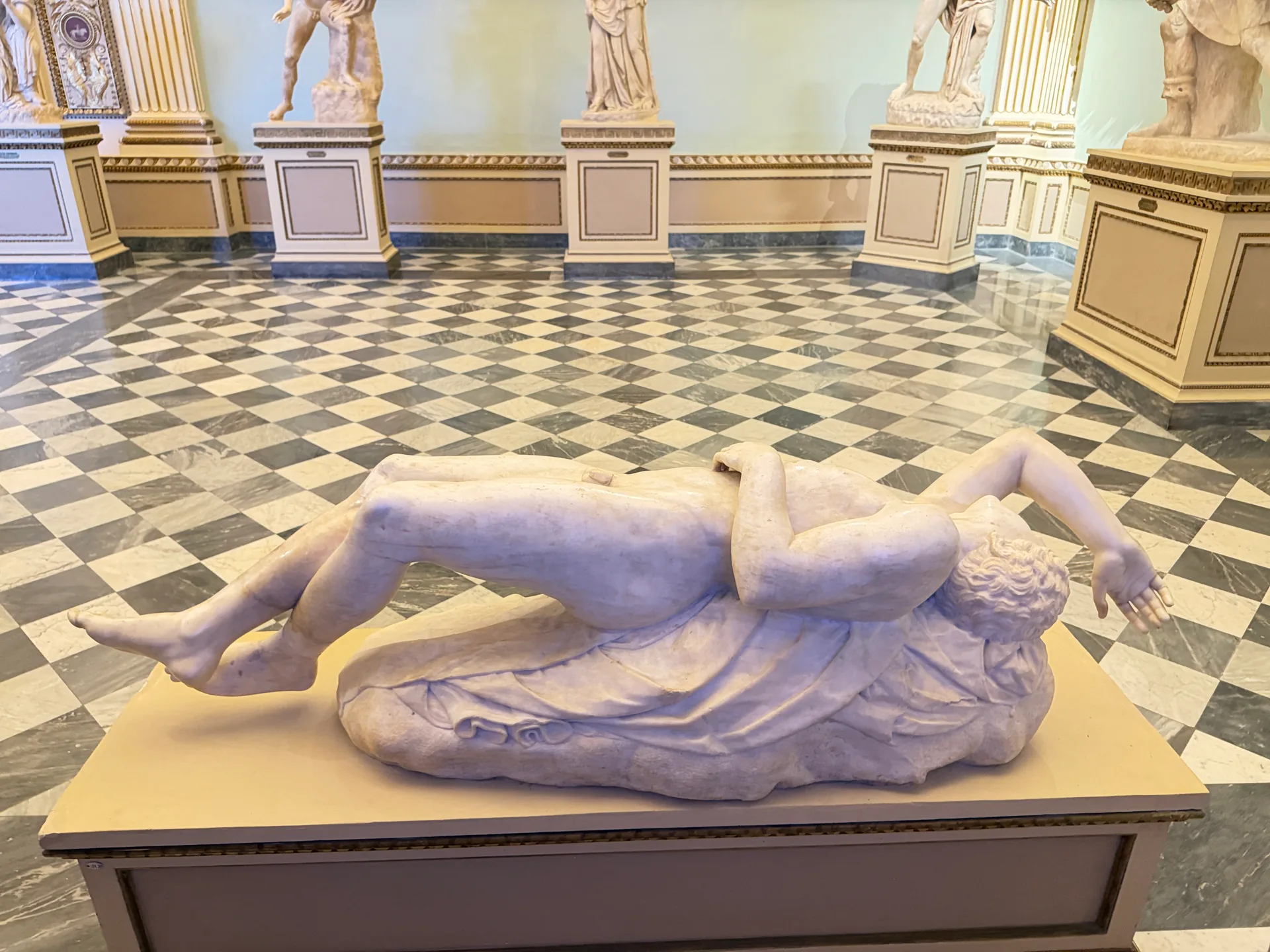 A dead Niobid lying on his plinth in the Sala della Niobe.