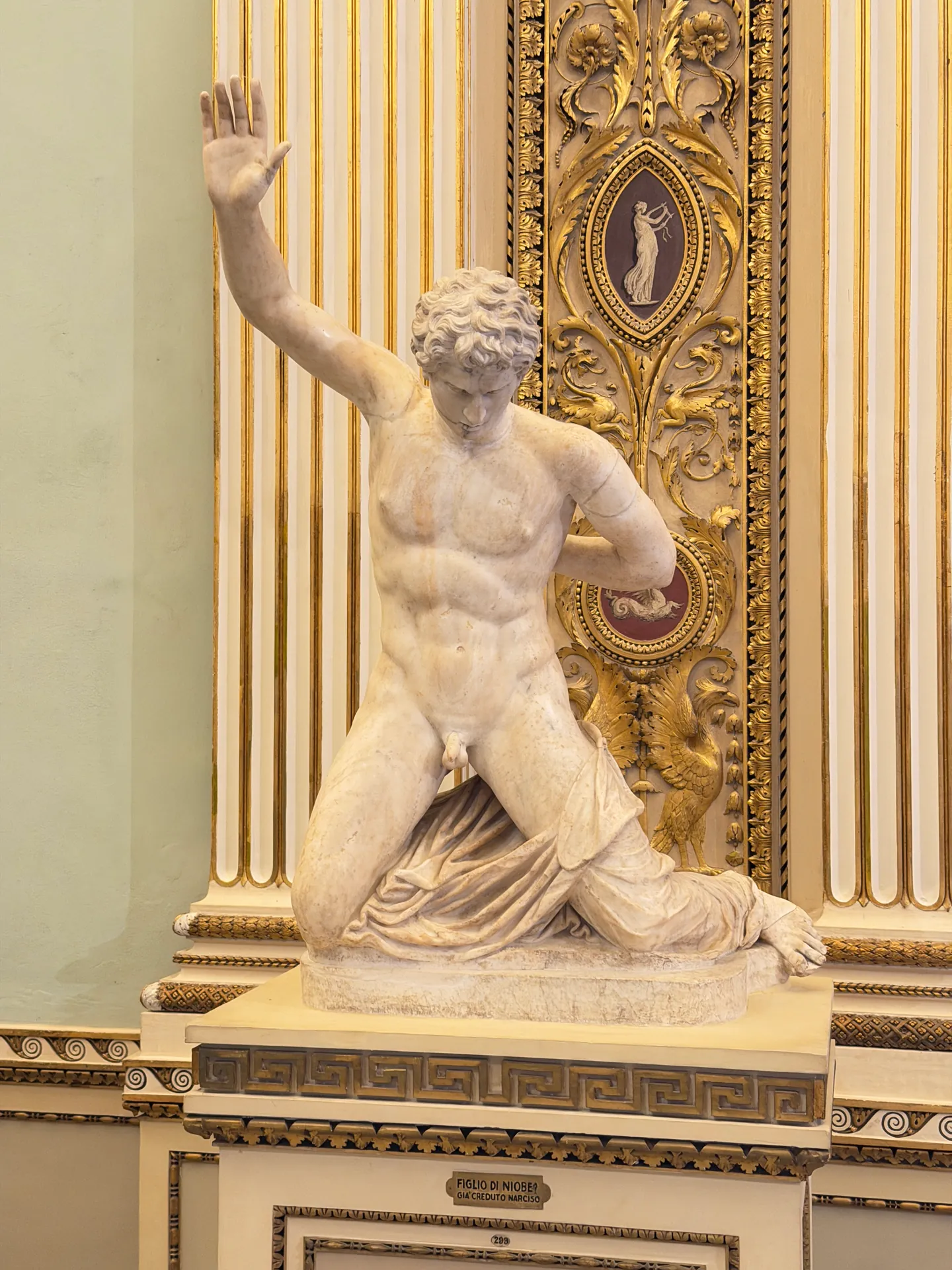 A son of Niobe falling with his right arm thrown up, on a Greek key plinth.