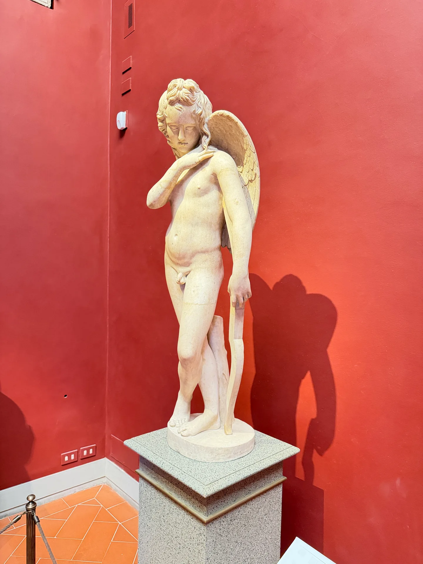 A second winged marble youth standing in the corner of the Cabinet of Ancient Marbles.
