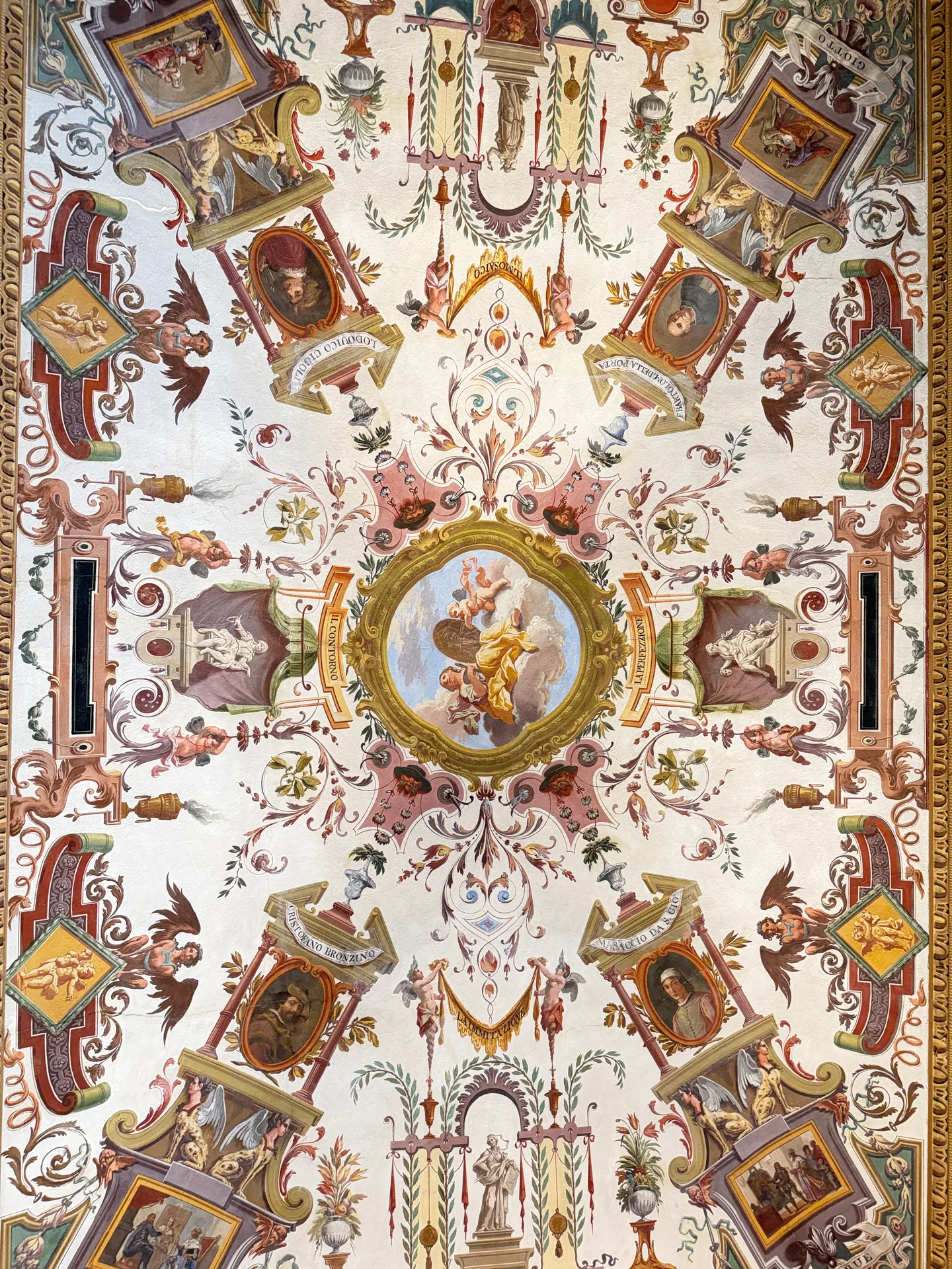 One bay of the Uffizi corridor ceiling seen straight up, painted with grotesque ornament on a pale ground.