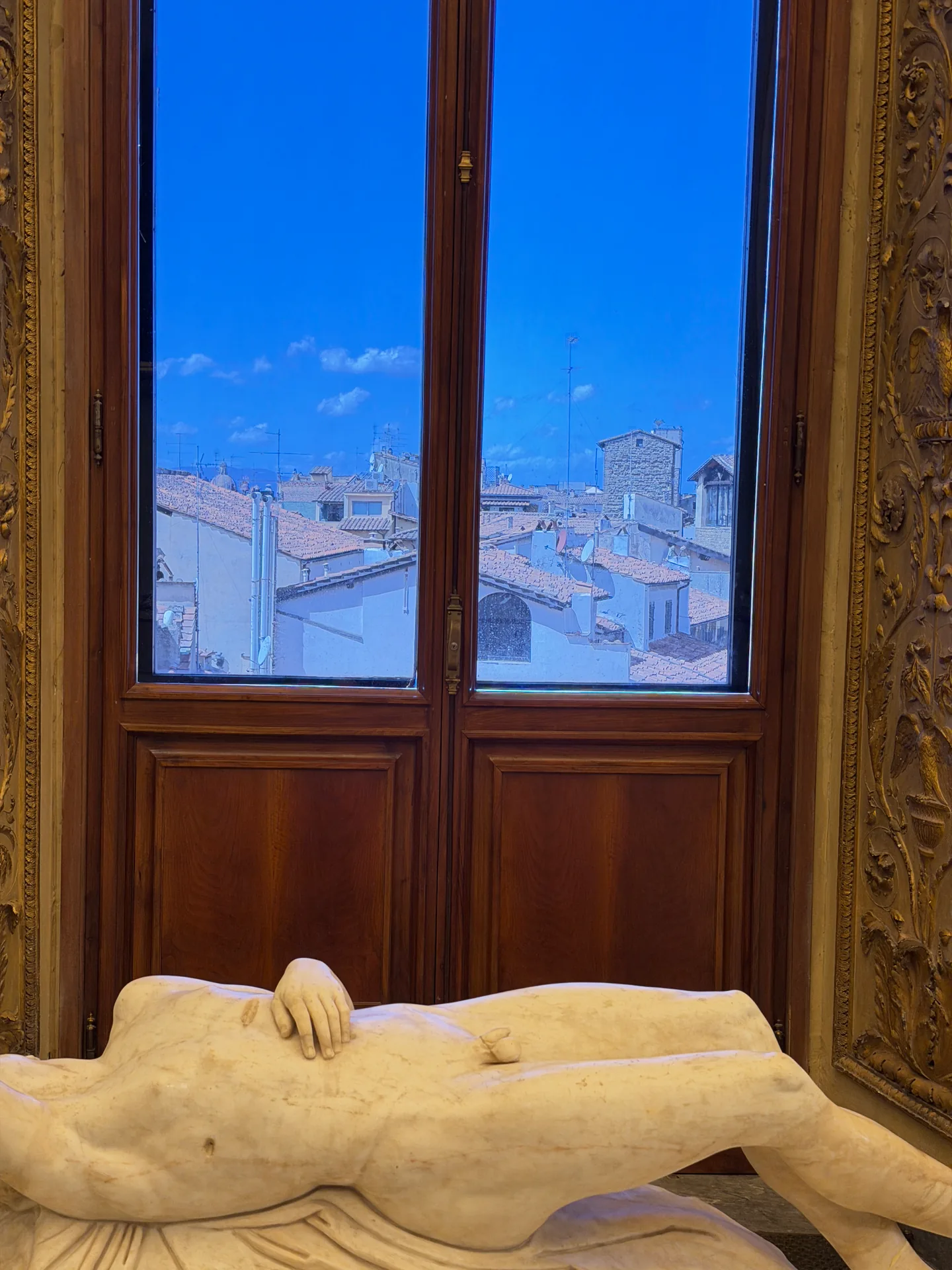 A dying Niobid lying before a window that looks out over the Oltrarno rooftops.