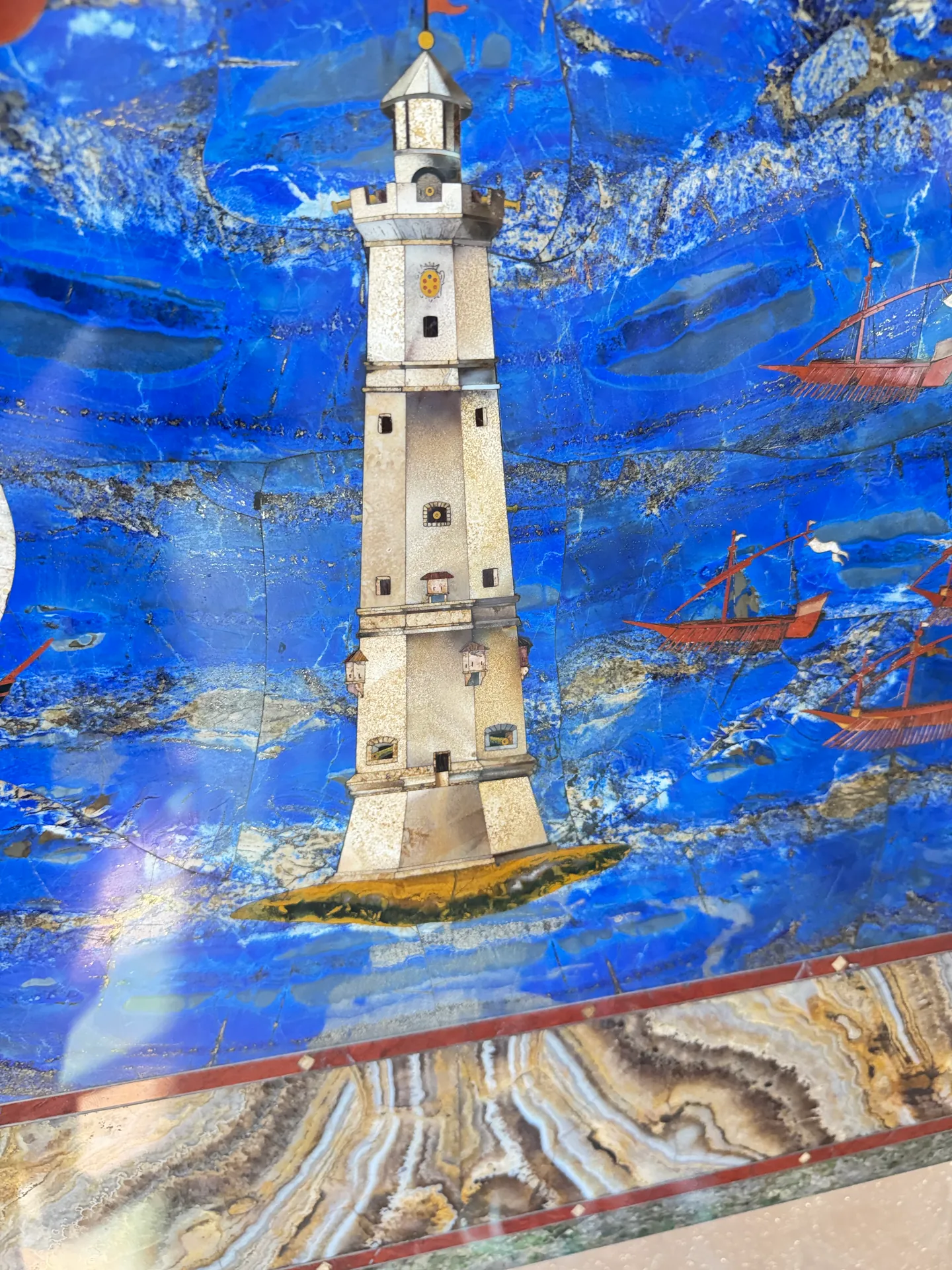 The inlaid lighthouse and the ships around it, a detail of the pietre dure harbour panel.