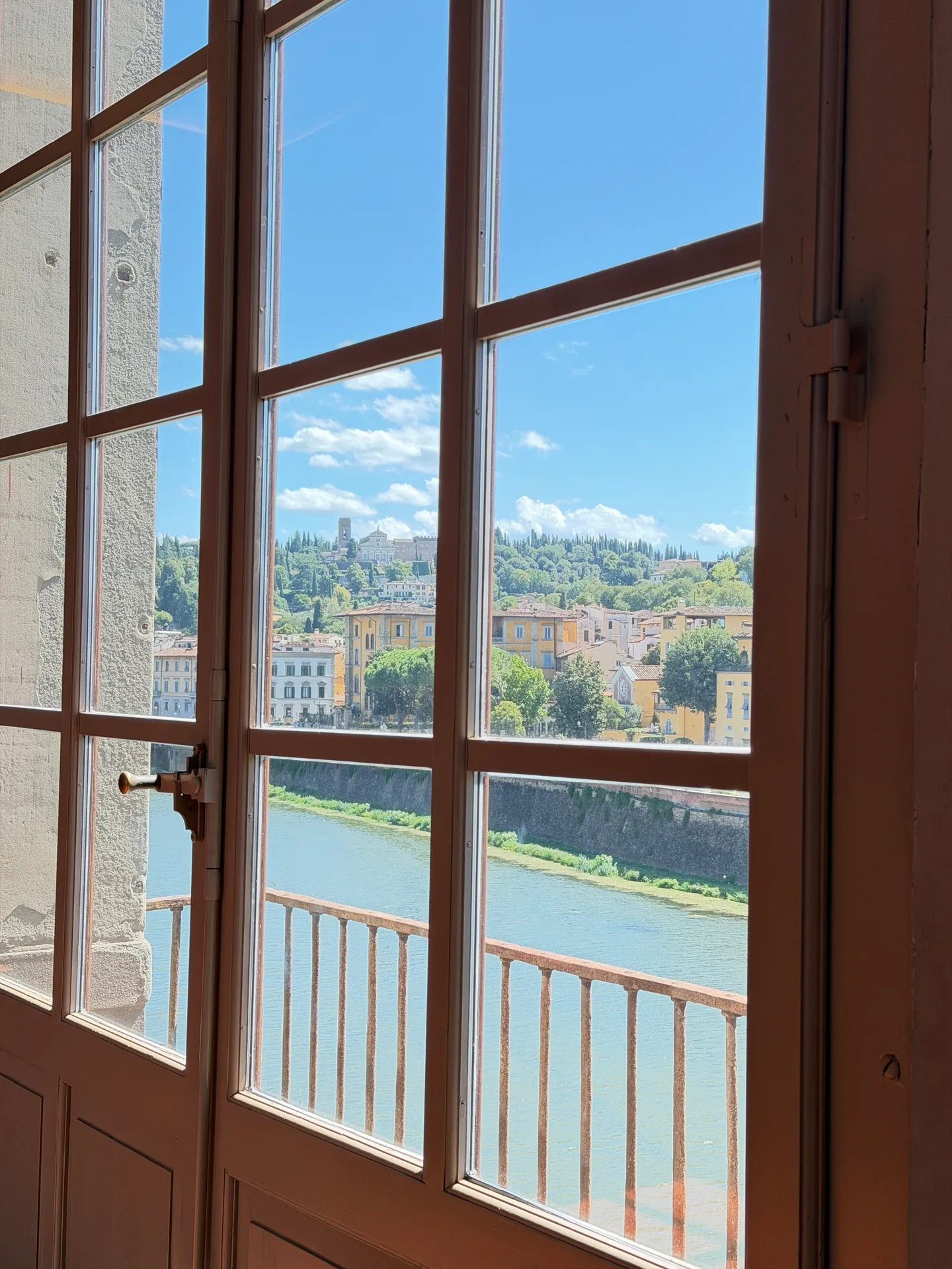 The Arno seen upstream through a tall window of the Uffizi.