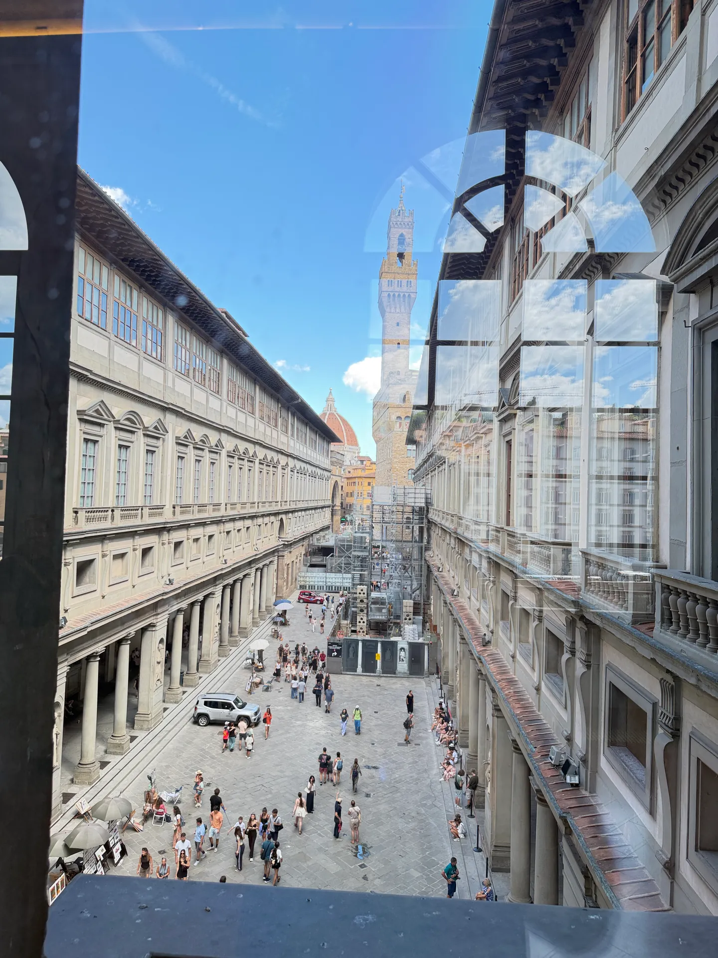 The Piazzale degli Uffizi seen from a gallery window, the Palazzo Vecchio tower closing the view.