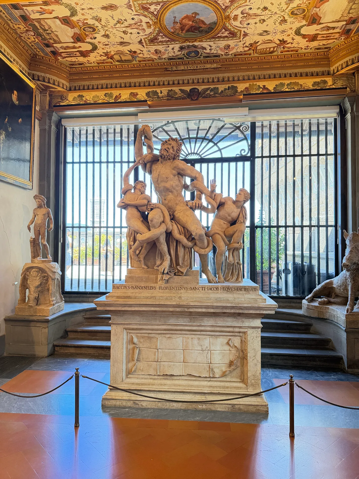 Bandinelli's marble copy of the Laocoon standing against a corridor window of the Uffizi.