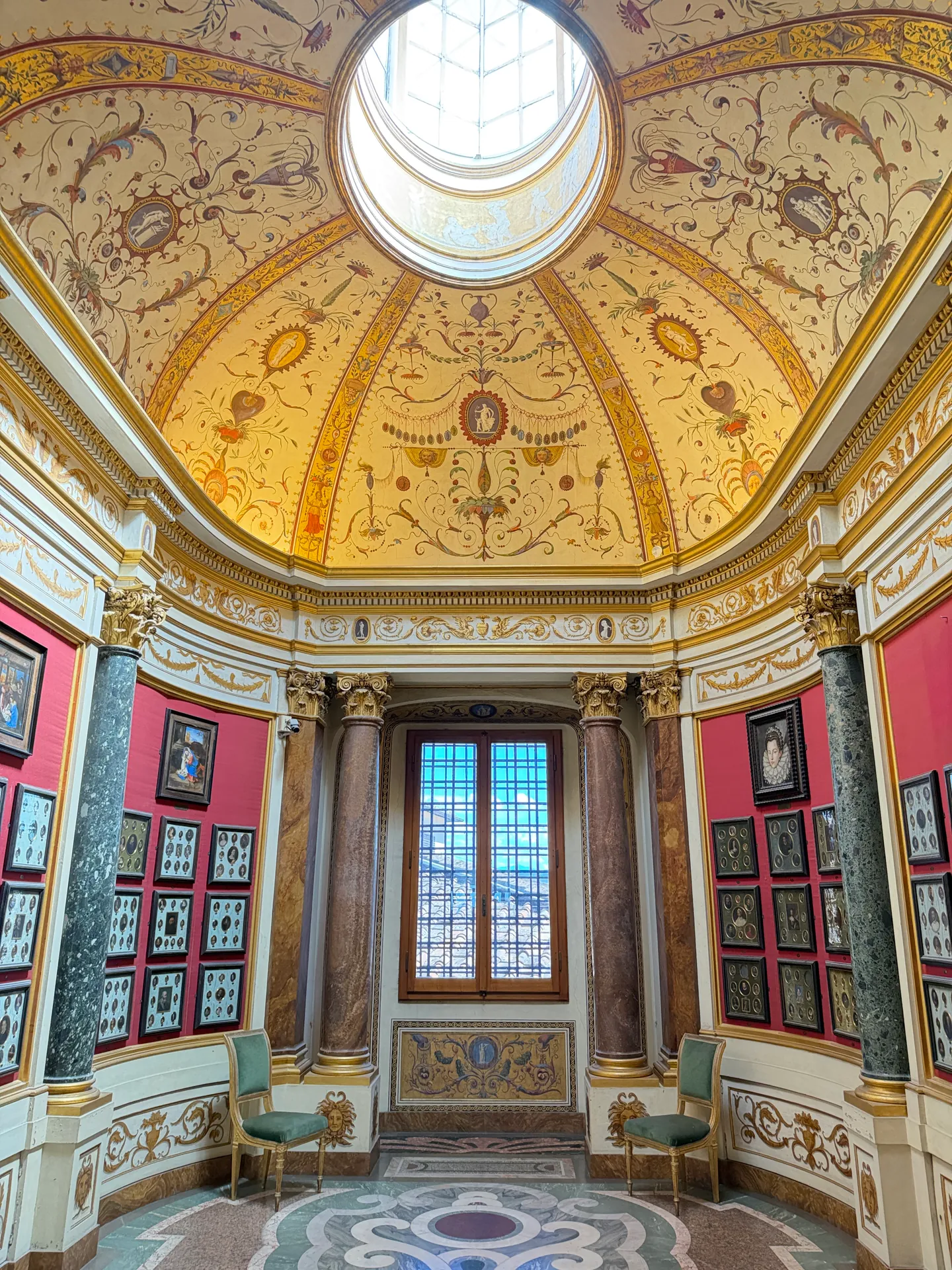 The Gabinetto delle Miniature in the Uffizi, its painted vault and oculus above deep red walls.