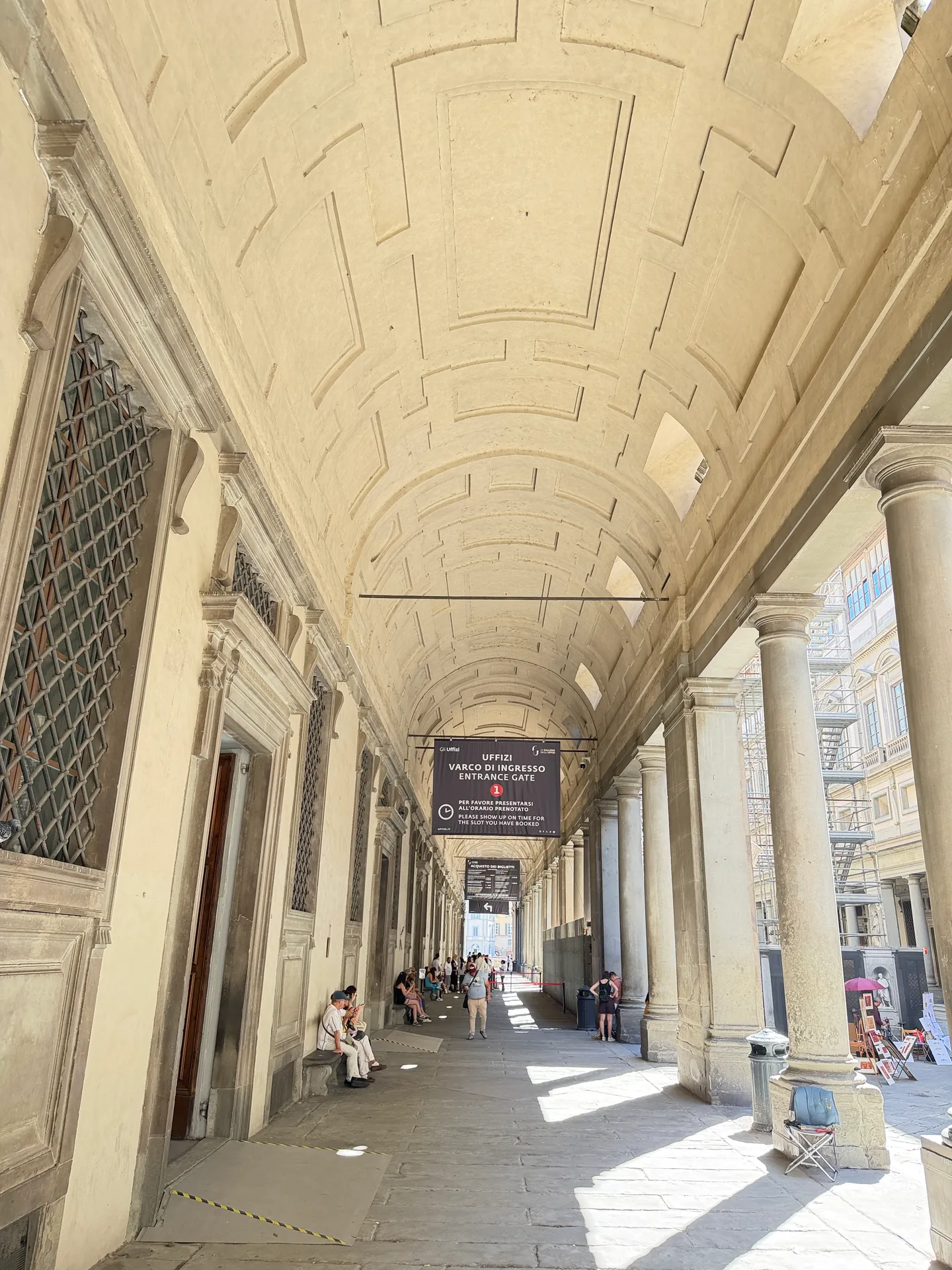 The vaulted ground floor portico of the Uffizi running the length of the wing, empty in early afternoon.