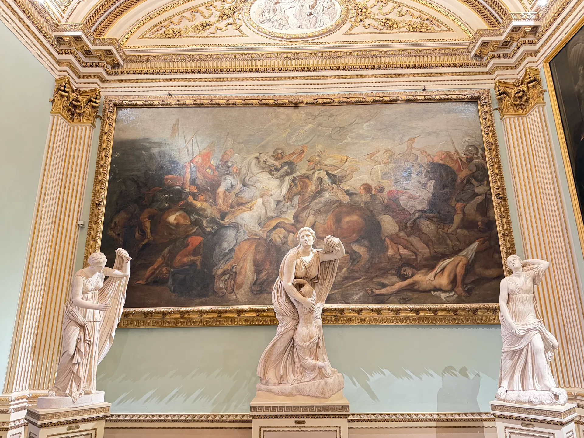 A large Rubens canvas hanging above the Niobid statues in the Sala della Niobe.