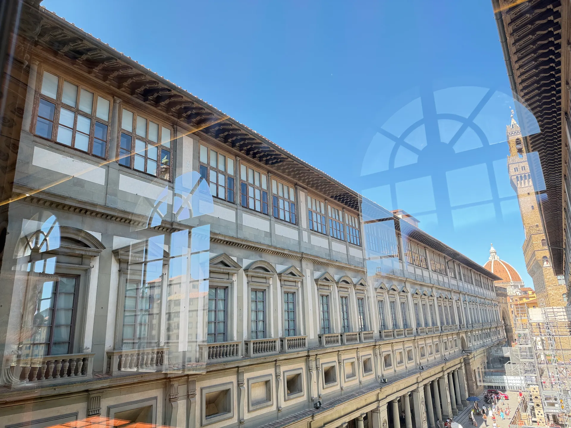The two wings of the Uffizi from outside, the Palazzo Vecchio tower and Brunelleschi's dome rising behind them.