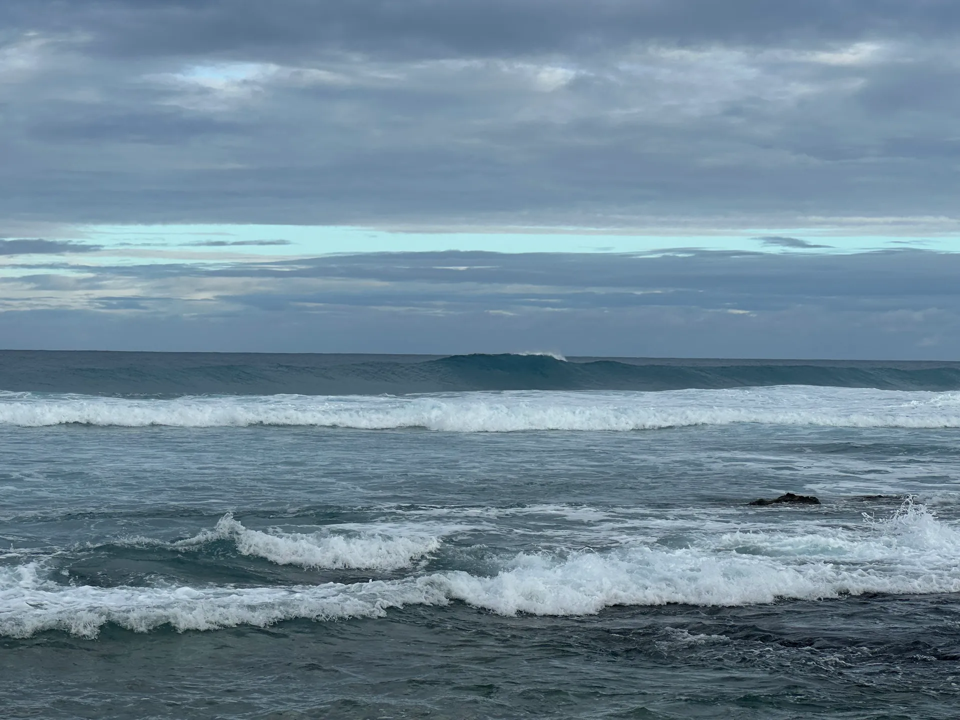A wave breaking on a grey morning off the Kohala coast