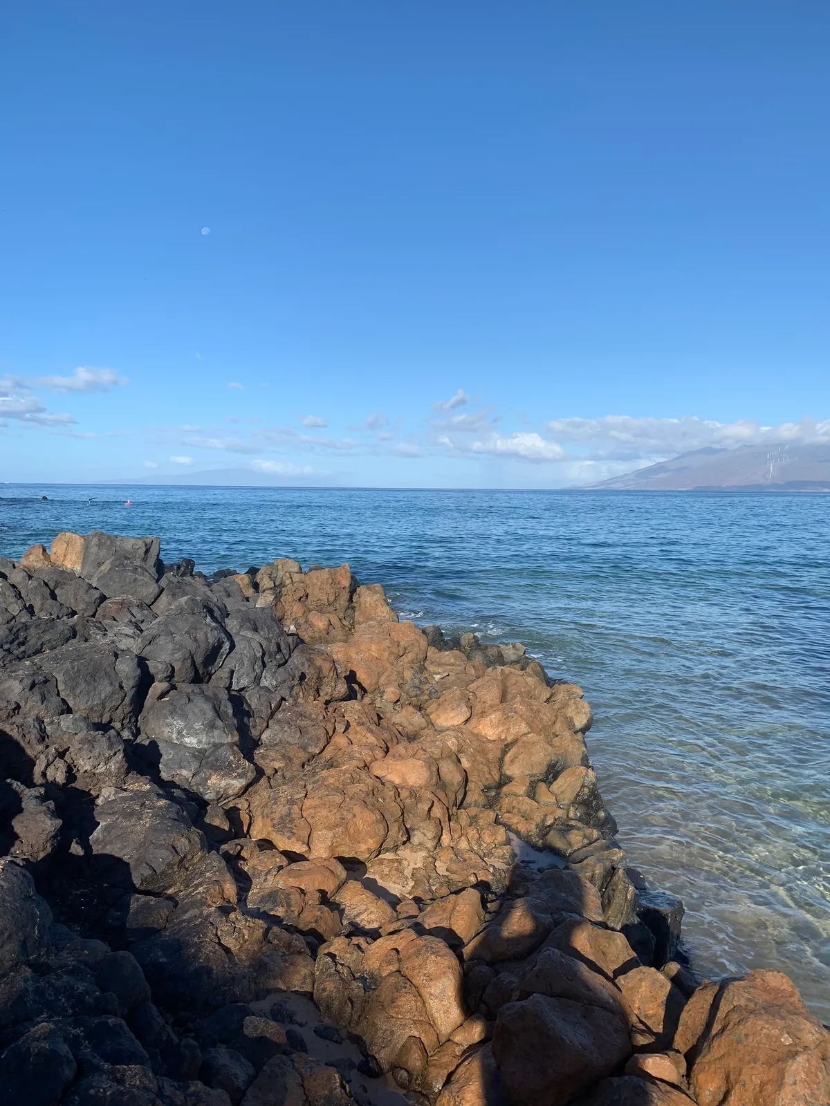 Rough lava rock ridge along the shoreline with ocean beyond