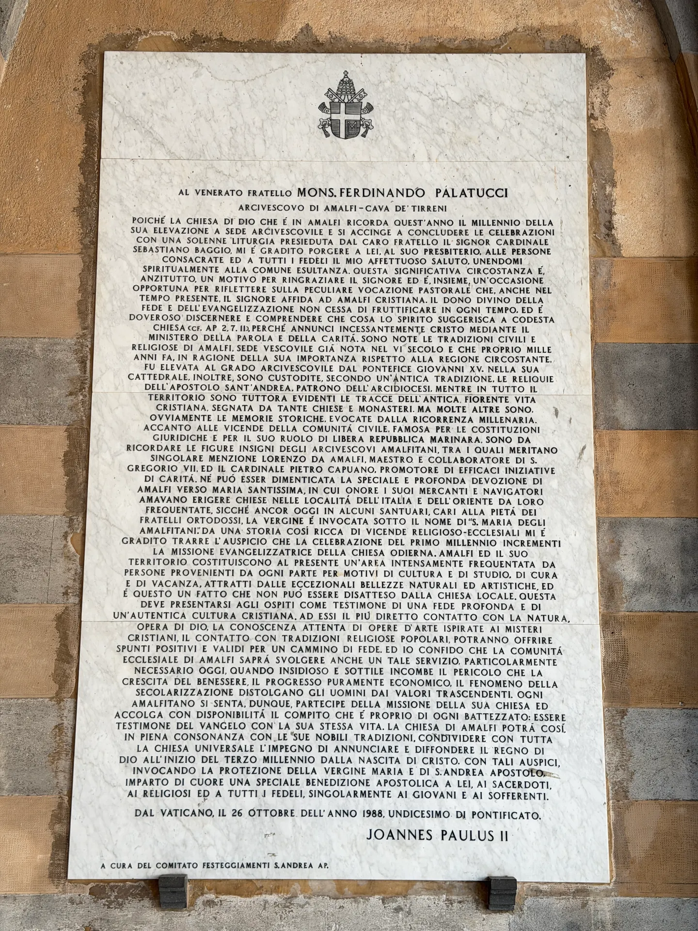 Marble panel inscribed with a 1988 letter of Pope John Paul II under the papal arms, on the cathedral atrium wall