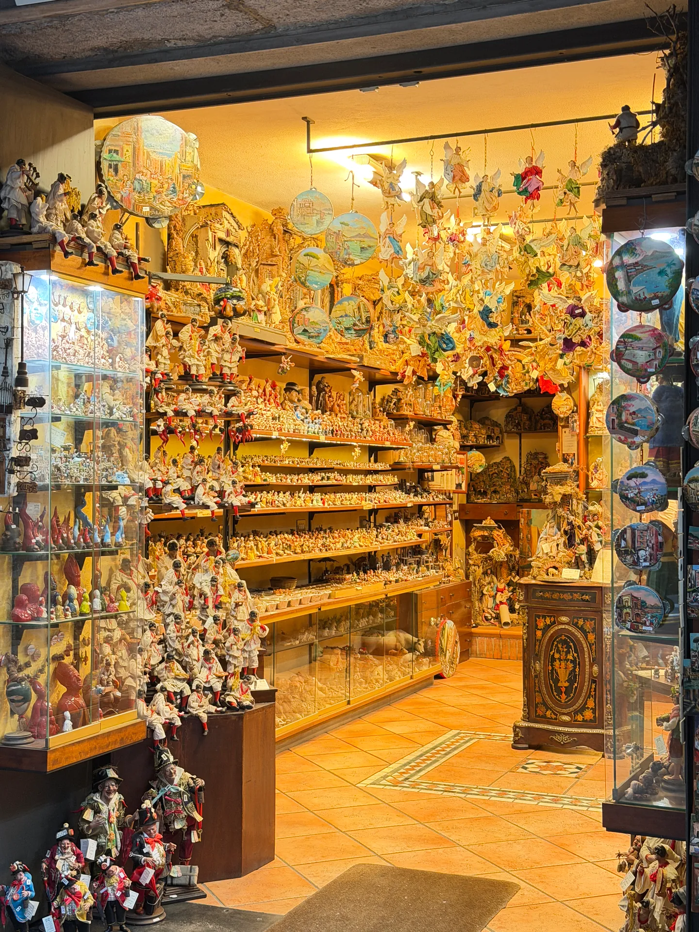 Shelves of figures filling a warmly lit shop on San Gregorio Armeno, Naples
