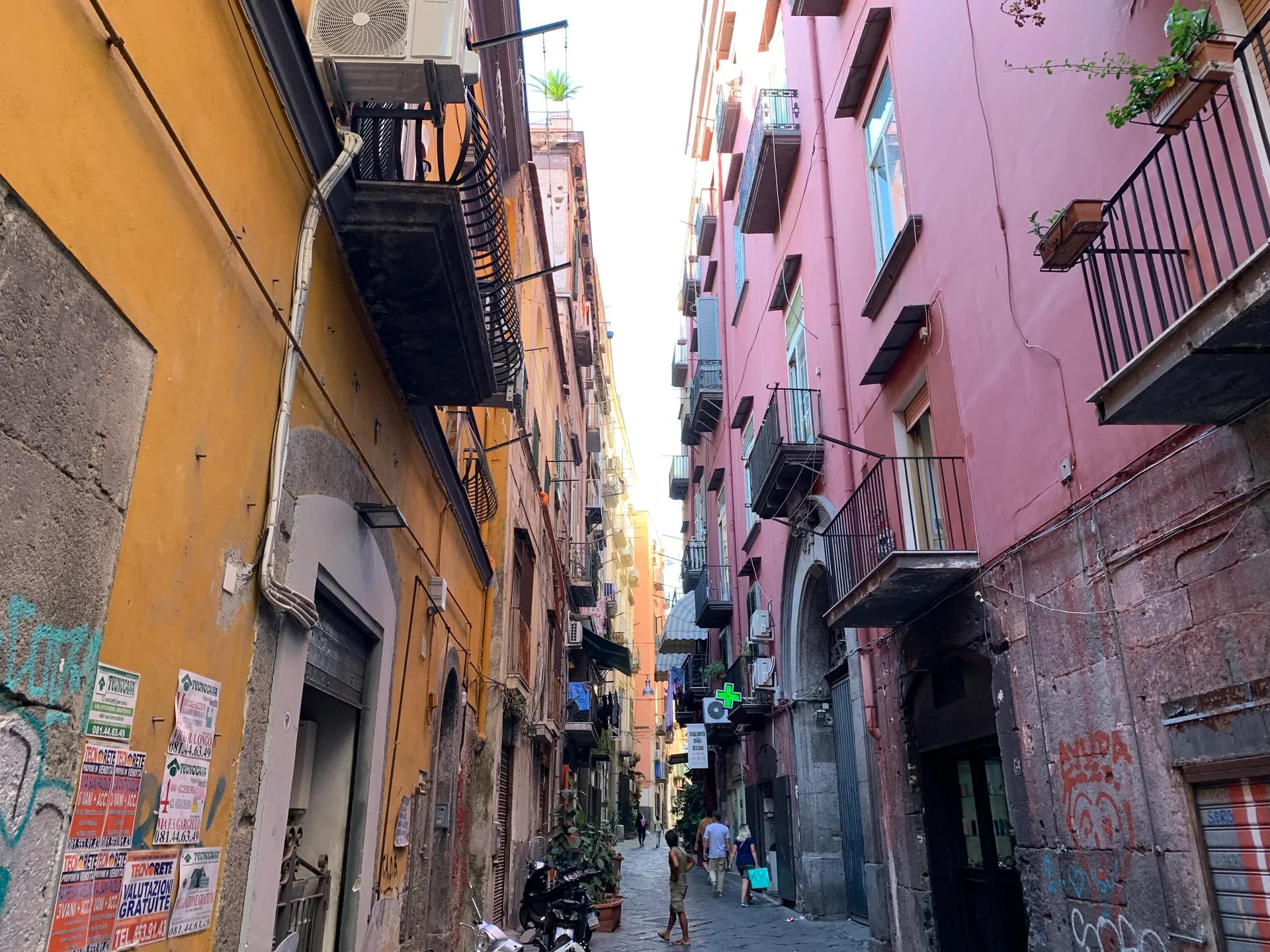 A narrow street of coloured buildings in the historic centre of Naples