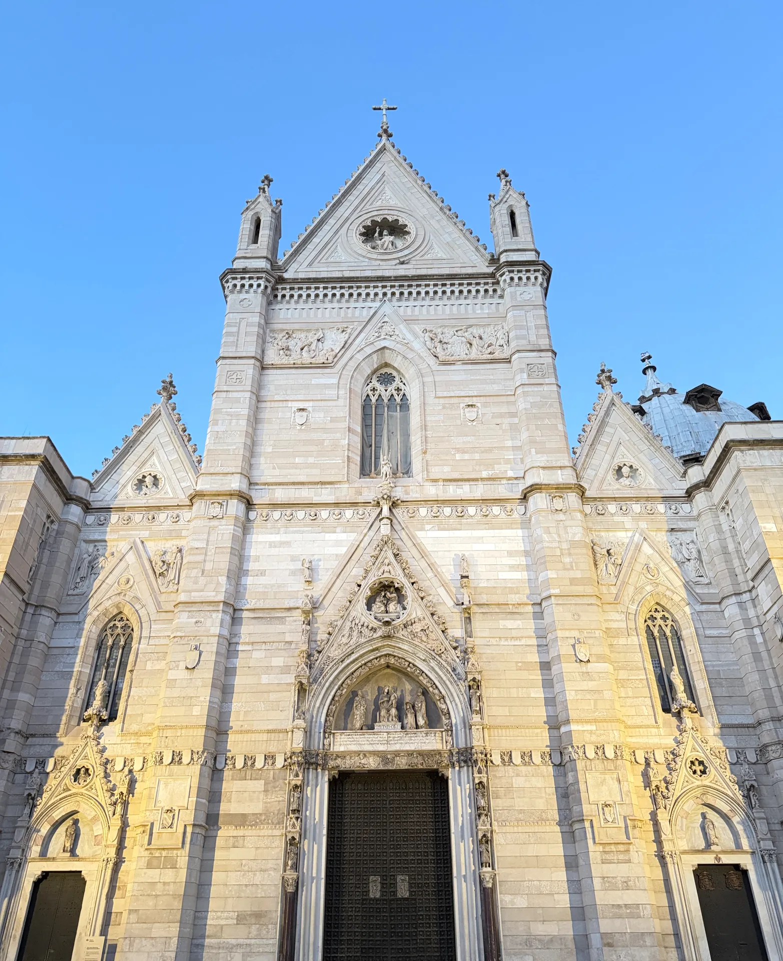 The marble Gothic facade of the Duomo of Naples with its central rose window