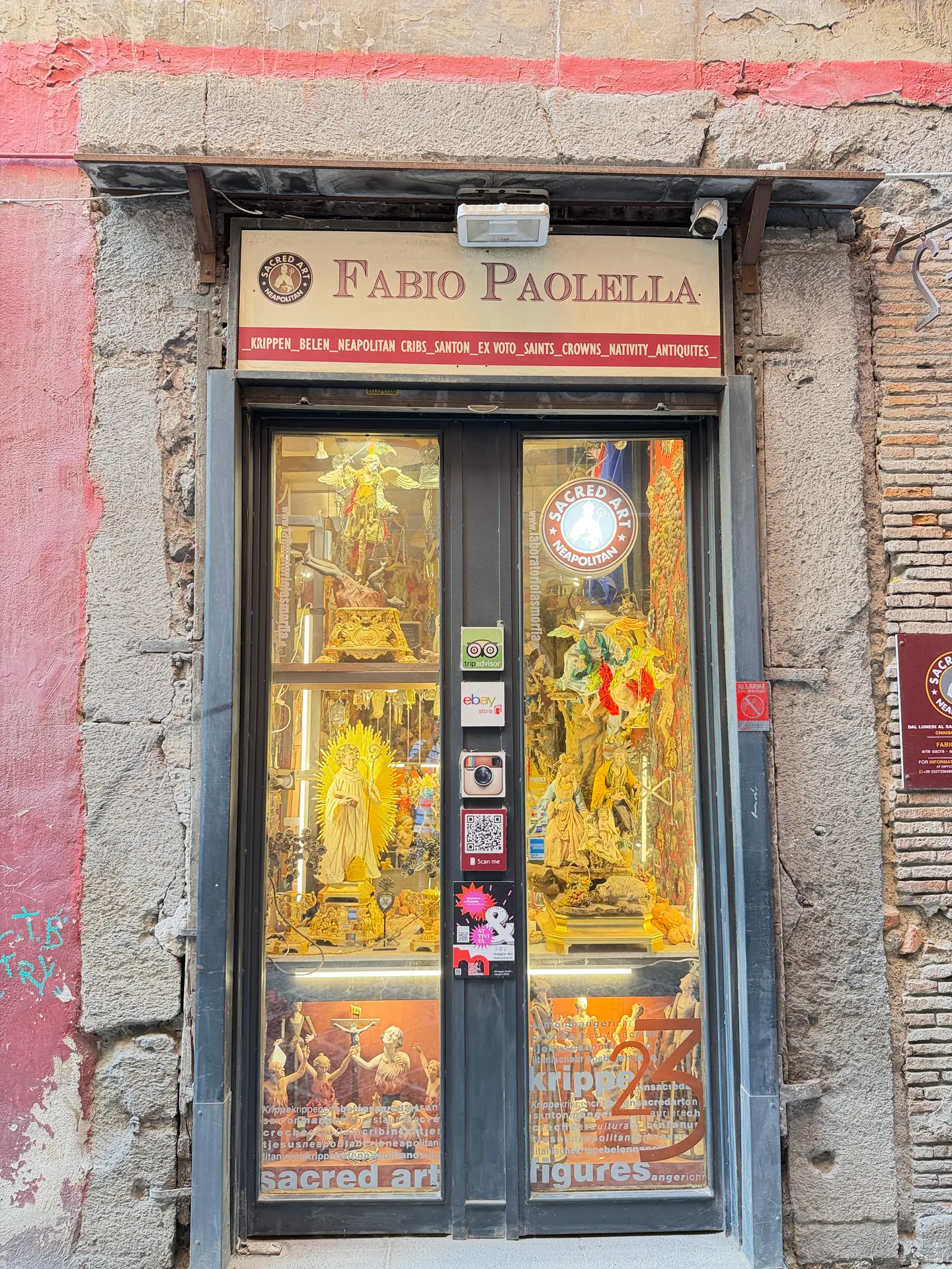 The Fabio Paolella shopfront with figures and sacred art in the window, Naples