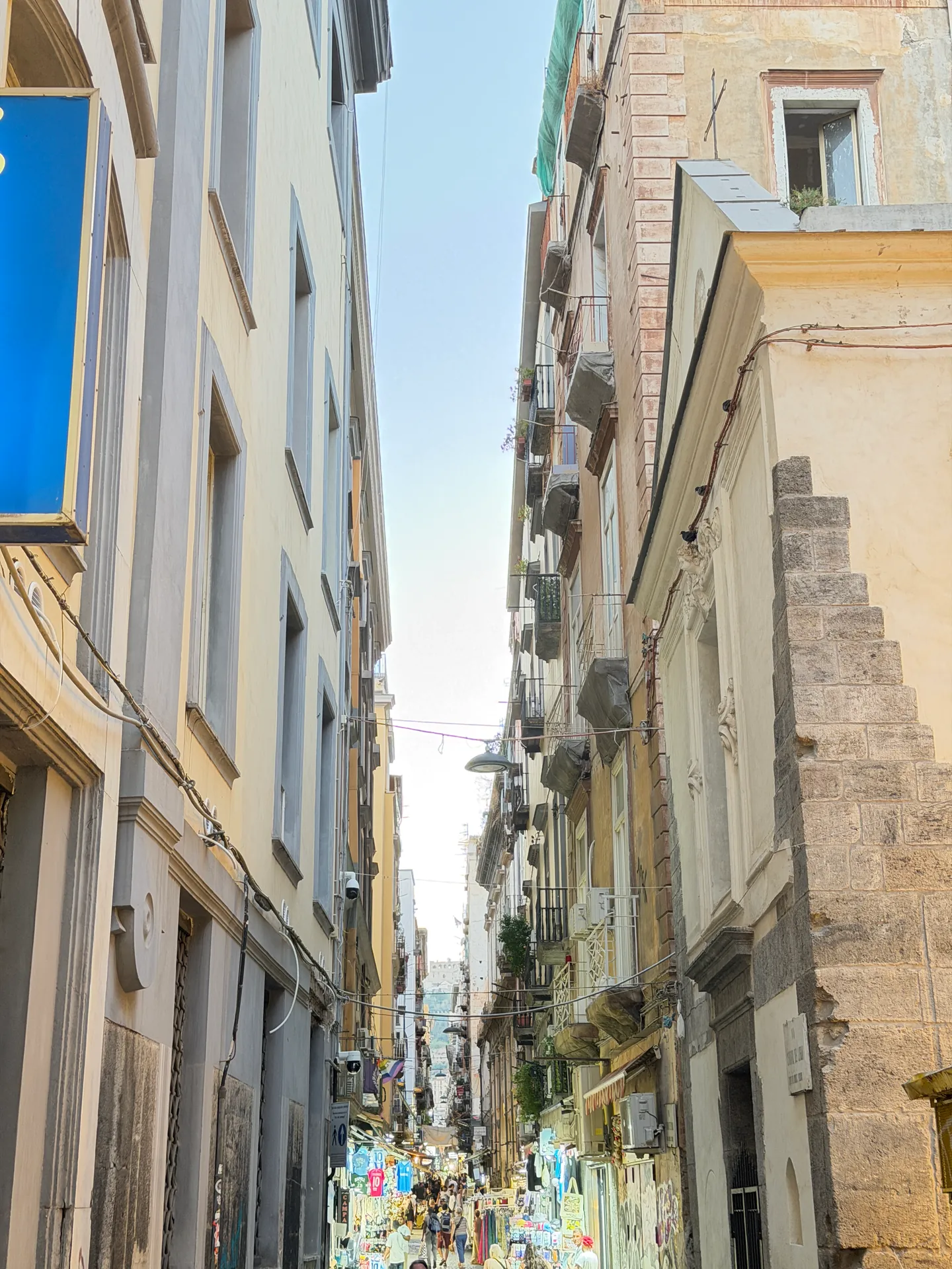 A long straight lane between tall buildings in the old centre of Naples