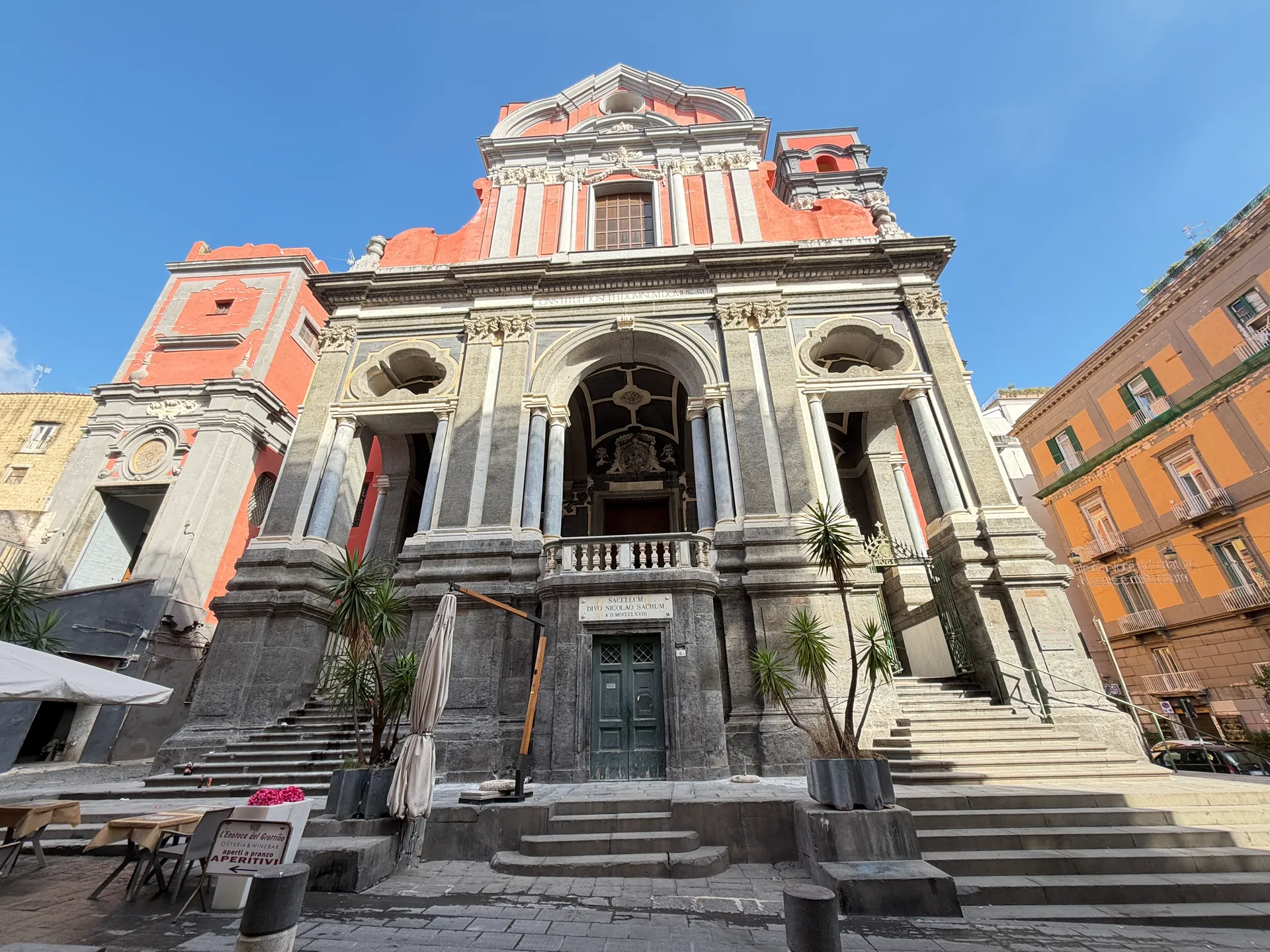 A church front with a raised loggia and a marble tablet over its lower door, Naples
