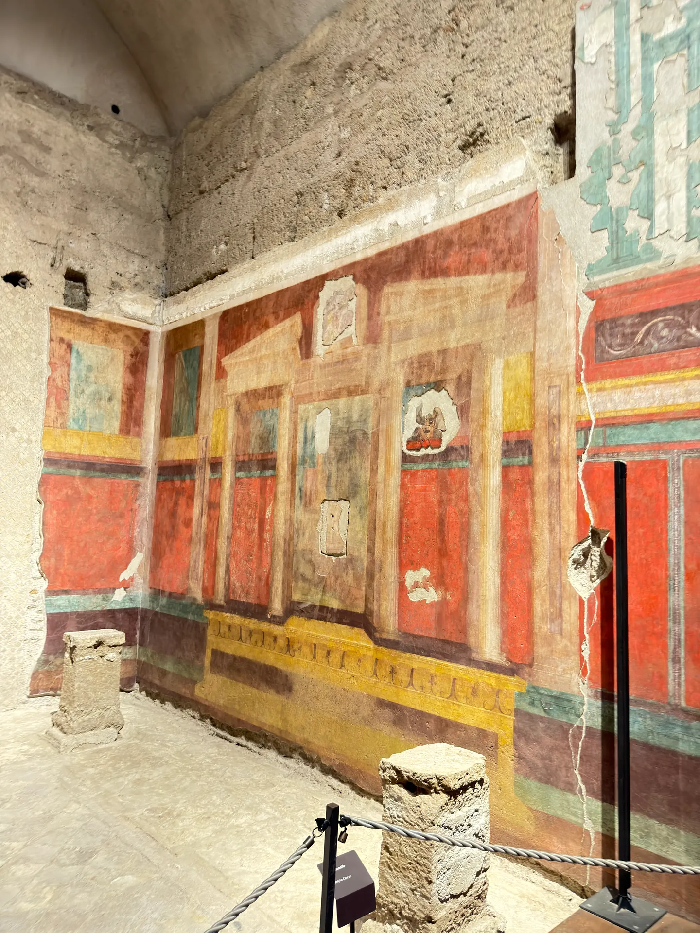 Long painted wall of a vaulted room in the House of Augustus, red panels under a moulded cornice.