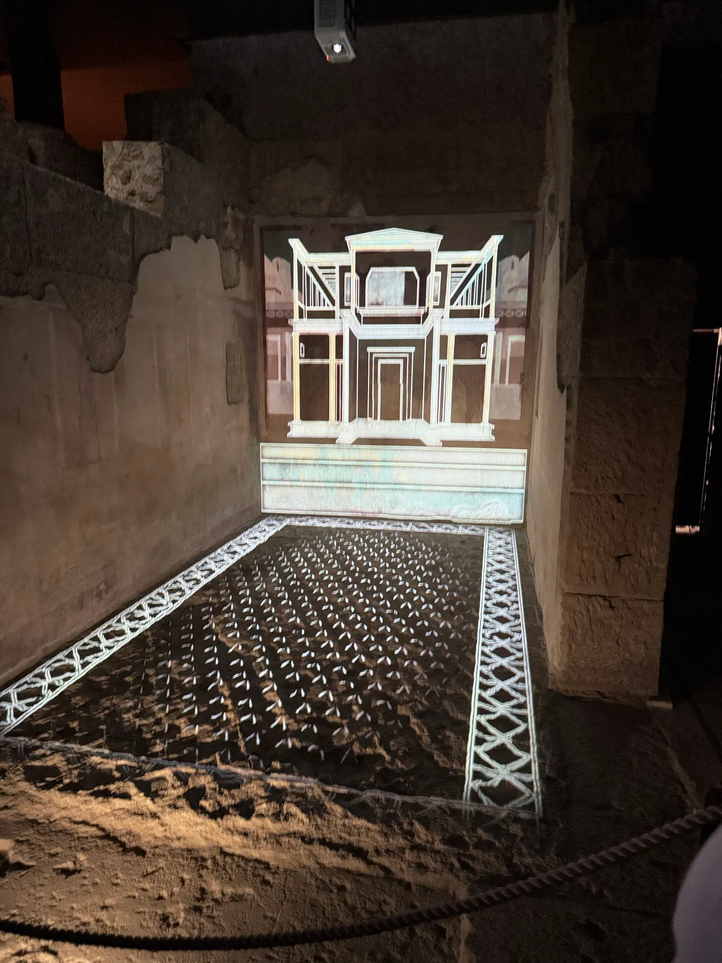 A projected reconstruction of the lost decoration fills the end wall and floor of a room, House of Augustus.